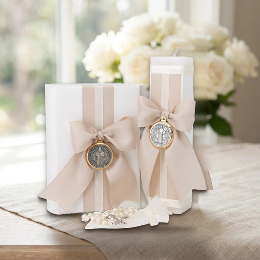 Kit Beige con moño y medalla San Benito sobre mesa con mantel de lino y rosas blancas – Casa Gala Puebla